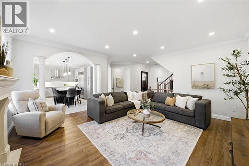 Living room featuring ornamental molding, arched walkways, wood finished floors, recessed lighting, and ornate columns - 4670 Bracknell Road, Burlington, ON - Indoor Photo Showing Living Room