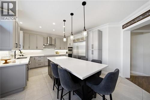 Kitchen with gray cabinets, a kitchen breakfast bar, crown molding, stainless steel appliances, and a center island - 4670 Bracknell Road, Burlington, ON - Indoor Photo Showing Other Room