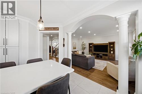 Dining space with arched walkways, ornate columns, ornamental molding, light tile patterned floors, and recessed lighting - 4670 Bracknell Road, Burlington, ON - Indoor