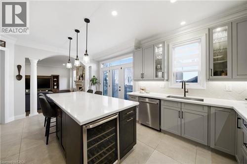 Kitchen with wine cooler, ornamental molding, a kitchen bar, stainless steel dishwasher, and open floor plan - 4670 Bracknell Road, Burlington, ON - Indoor Photo Showing Kitchen With Upgraded Kitchen