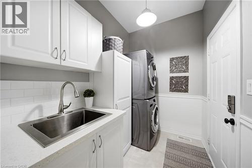 Laundry area with stacked washer / drying machine and cabinet space - 4670 Bracknell Road, Burlington, ON - Indoor Photo Showing Laundry Room