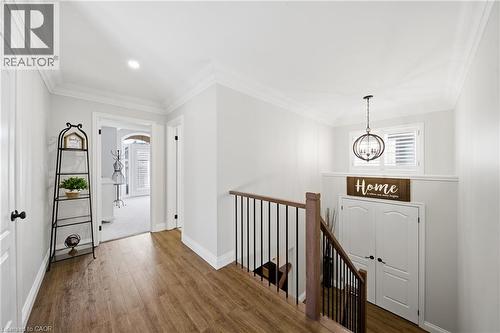 Hall featuring wood finished floors, crown molding, an upstairs landing, and suspended lighting - 4670 Bracknell Road, Burlington, ON - Indoor Photo Showing Other Room