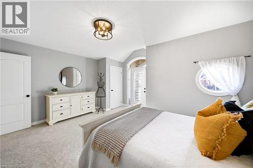 Bedroom featuring multiple windows, light colored carpet, vaulted ceiling, and suspended lighting - 4670 Bracknell Road, Burlington, ON - Indoor Photo Showing Bedroom