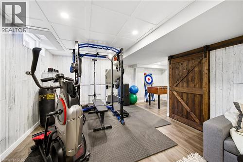 Exercise room featuring wood walls, light wood-style floors, a barn door, and recessed lighting - 4670 Bracknell Road, Burlington, ON - Indoor