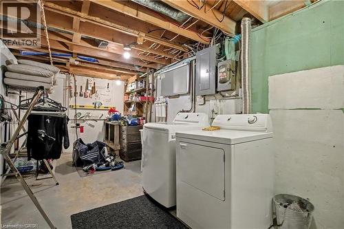 Laundry area featuring unfinished concrete floors, washing machine and clothes dryer, and electric panel - 11 Carwyn Crescent, Hamilton, ON - Indoor Photo Showing Laundry Room