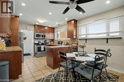 Kitchen with a peninsula, stainless steel appliances, recessed lighting, light stone counters, and ceiling fan - 11 Carwyn Crescent, Hamilton, ON - Indoor