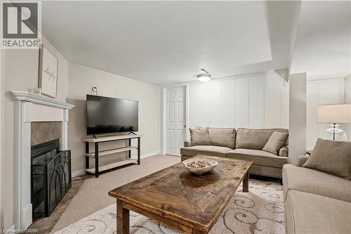 Living room with light colored carpet and a glass covered fireplace - 11 Carwyn Crescent, Hamilton, ON - Indoor Photo Showing Living Room With Fireplace