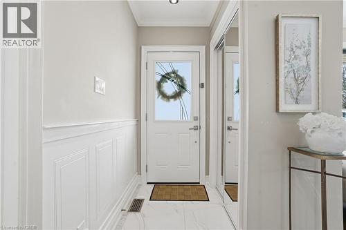 Imagine meal prep in this STELLAR kitchen; features bright white cabinetry, crown molding, stainless steel appliances, a tray ceiling, hardwood floors, skylight & accent stone wall! - 208 East 44Th Street, Hamilton, ON - Indoor Photo Showing Other Room