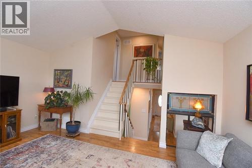 Staircase with a textured ceiling and wood-style floors - 3200 Greenbough Crescent, Burlington, ON - Indoor Photo Showing Living Room