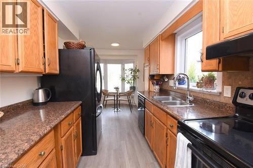 Kitchen featuring black appliances and loads of wood finish cabinetry - 3200 Greenbough Crescent, Burlington, ON - Indoor Photo Showing Kitchen With Double Sink