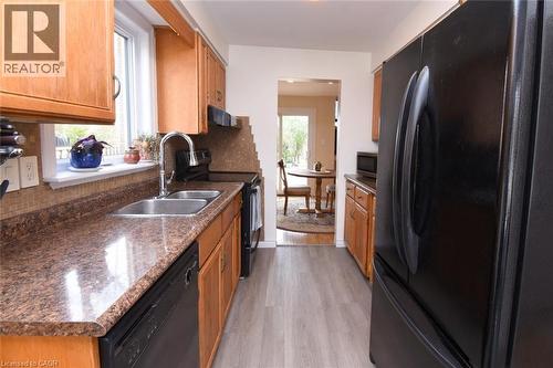 Kitchen featuring black appliances, tasteful backsplash, and wood finish cabinetry - 3200 Greenbough Crescent, Burlington, ON - Indoor Photo Showing Kitchen With Double Sink