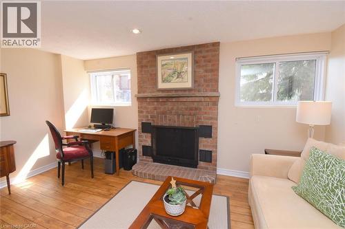 Lower level Family room featuring a brick wood-burning fireplace - 3200 Greenbough Crescent, Burlington, ON - Indoor Photo Showing Living Room With Fireplace