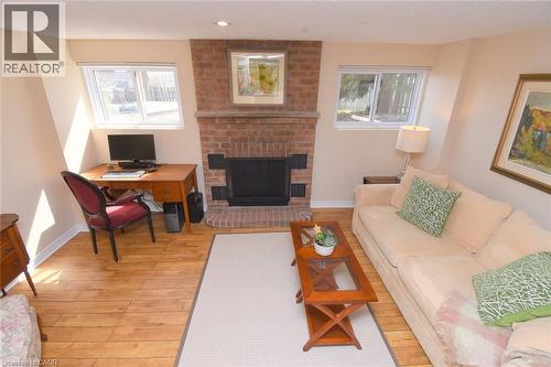 Bright Lower level family room featuring a brick wood-burning fireplace - 3200 Greenbough Crescent, Burlington, ON - Indoor Photo Showing Living Room With Fireplace