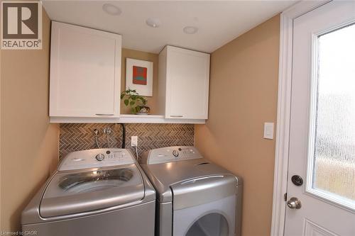 Laundry room featuring washer and dryer, healthy amount of natural light, and cabinet space - 3200 Greenbough Crescent, Burlington, ON - Indoor Photo Showing Laundry Room