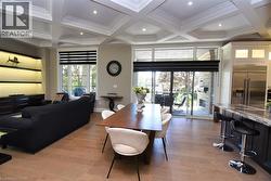 Dining space featuring coffered ceiling, light wood-type flooring, recessed lighting, and ornamental molding - 