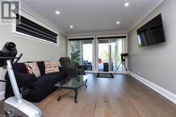 Living room with wood finished floors, ornamental molding, and recessed lighting - 