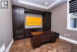 Office area featuring parquet floors and a tray ceiling - 