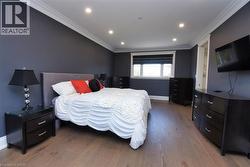Bedroom with crown molding, wood finished floors, and recessed lighting - 
