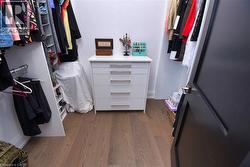 Walk in closet with dark wood-style floors - 