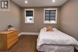 Bedroom featuring dark wood-style floors and baseboards - 