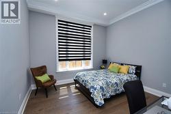 Bedroom featuring dark wood-style floors, crown molding, and recessed lighting - 