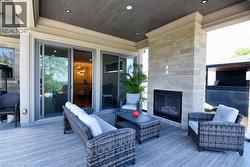Wooden terrace featuring an outdoor living space with a fireplace - 