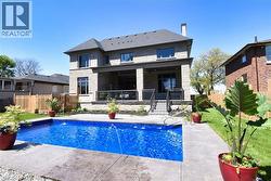 Back of property with a patio area, stone siding, a fenced backyard, and a chimney - 