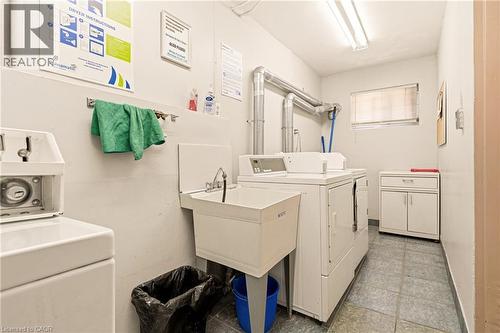 Community laundry room featuring washing machine and clothes dryer - 2373 E King Street E Unit# 45, Hamilton, ON - Indoor Photo Showing Laundry Room