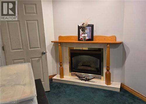 Detailed view of carpet flooring and a fireplace with raised hearth - 67 Pinemeadow Crescent, Waterloo, ON - Indoor Photo Showing Other Room With Fireplace