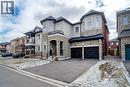 View of front facade with stone siding, stucco siding, asphalt driveway, and an attached garage - 150 Goodwin Crescent Unit# Bsmt, Milton, ON  - Outdoor With Facade 