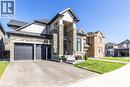 View of front of house featuring stone siding, a front lawn, and driveway - 72 Pond View Gate, Waterdown, ON  - Outdoor With Facade 