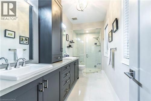 Full bath featuring double vanity, a marble finish shower, light marble finish flooring, and a chandelier - 72 Pond View Gate, Waterdown, ON - Indoor Photo Showing Bathroom