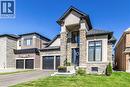 View of front of home with stone siding, a front lawn, and driveway - 72 Pond View Gate, Waterdown, ON  - Outdoor With Facade 