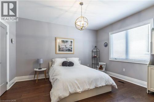 Bedroom with dark wood-style floors and hanging lights - 72 Pond View Gate, Waterdown, ON - Indoor Photo Showing Bedroom