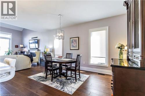 Dining space featuring dark wood-style flooring, suspended lighting, and vaulted ceiling - 72 Pond View Gate, Waterdown, ON - Indoor Photo Showing Dining Room