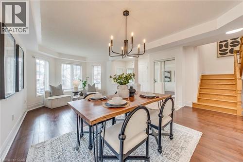 Dining room featuring a tray ceiling, wood-type flooring, and a chandelier - 5811 Page Crescent, Burlington, ON - Indoor Photo Showing Dining Room