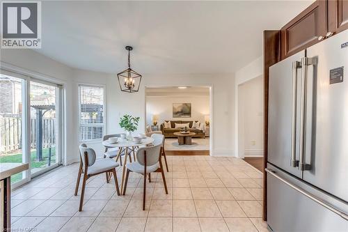 Dining room featuring a chandelier and light tile patterned floors - 5811 Page Crescent, Burlington, ON - Indoor Photo Showing Dining Room