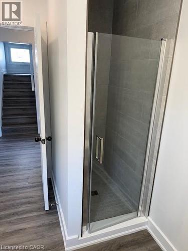 Full bath featuring dark wood-style floors and a stall shower - 322 Upper Gage Avenue, Hamilton, ON - Indoor Photo Showing Bathroom