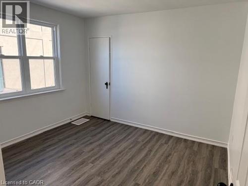 Spare room featuring dark wood finished floors and baseboards - 322 Upper Gage Avenue, Hamilton, ON - Indoor Photo Showing Other Room