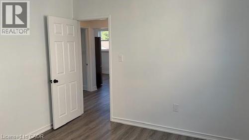 Unfurnished room featuring baseboards and dark wood-type flooring - 322 Upper Gage Avenue, Hamilton, ON - Indoor Photo Showing Other Room