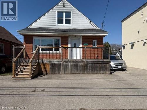 View of front facade featuring brick siding and a wooden deck - 322 Upper Gage Avenue, Hamilton, ON - Outdoor With Deck Patio Veranda