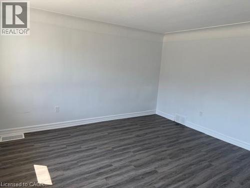 Unfurnished room featuring dark wood-style flooring and baseboards - 322 Upper Gage Avenue, Hamilton, ON - Indoor Photo Showing Other Room