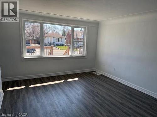 Spare room with dark wood finished floors and a residential view - 322 Upper Gage Avenue, Hamilton, ON - Indoor Photo Showing Other Room