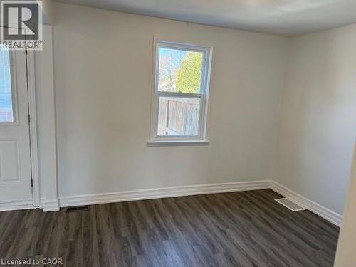 Unfurnished room featuring dark wood-style floors and baseboards - 322 Upper Gage Avenue, Hamilton, ON - Indoor Photo Showing Other Room