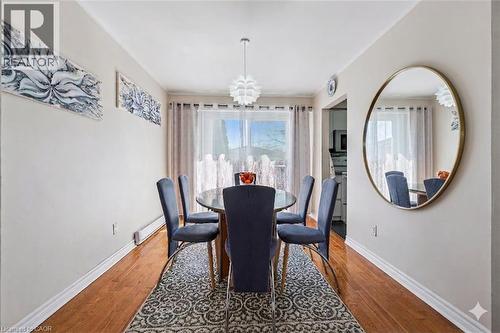 Dining space with hanging lights, hardwood / wood-style floors, and a baseboard heating unit - 55 Ralgreen Crescent, Kitchener, ON - Indoor Photo Showing Dining Room
