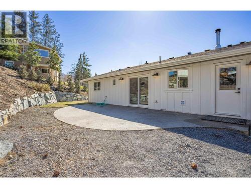 Back of house with flat grass area and aggregate patio - 488 Sheila Crescent, Kelowna, BC - Outdoor