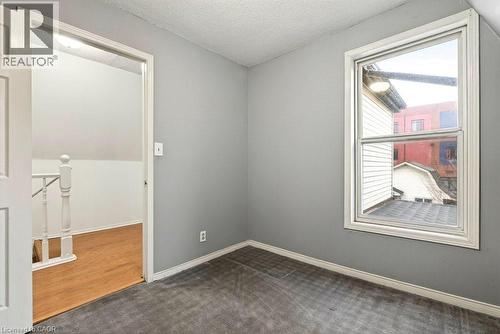 Unfurnished room with dark colored carpet and a textured ceiling - 23 Frederick Avenue, Hamilton, ON - Indoor Photo Showing Other Room