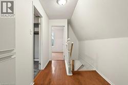 Corridor with an upstairs landing and wood-type flooring - 