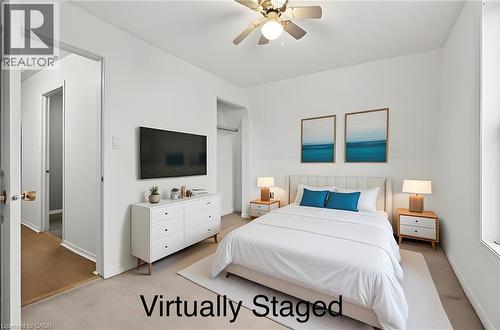 This bright room features a ceiling fan, light-colored walls, and a window providing natural light - 23 Frederick Avenue, Hamilton, ON - Indoor Photo Showing Bedroom