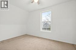 Empty room featuring carpet flooring, a ceiling fan, and a textured ceiling - 